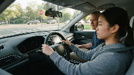 Young driver practicing vehicle control during a supervised driving lesson with an instructor