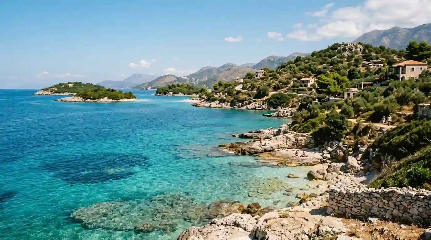 Turquoise Ionian Sea along Albania's scenic Riviera with green hills and a rocky coastline.